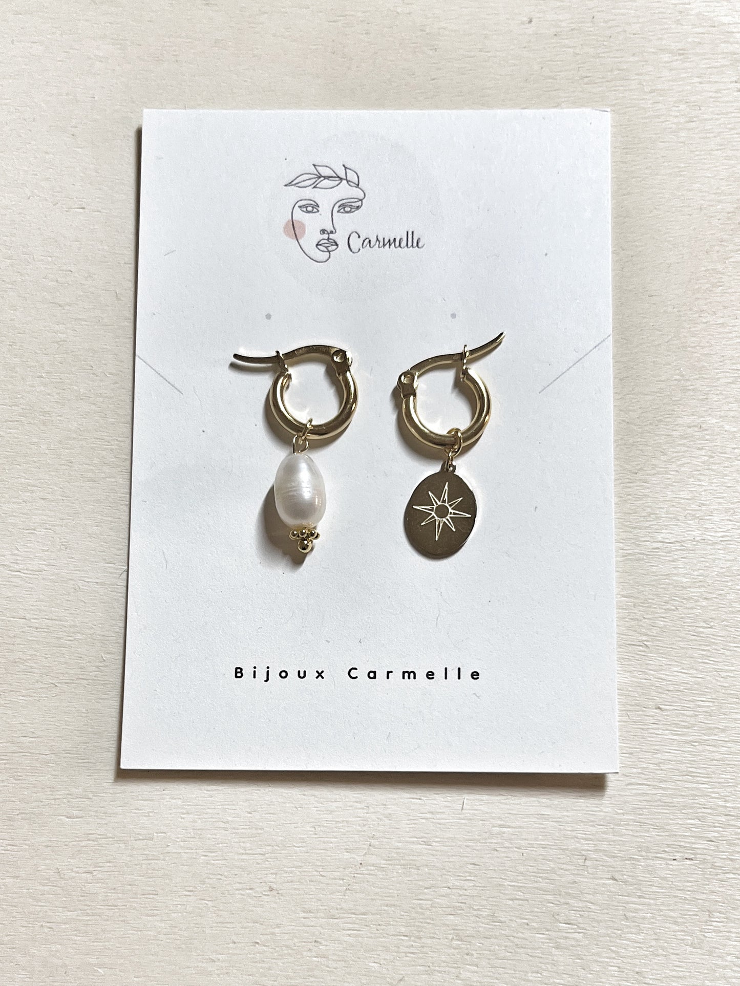 Boucles d’oreilles asymétriques en acier inoxydable avec perle de culture d’eau douce et étoile du Nord.