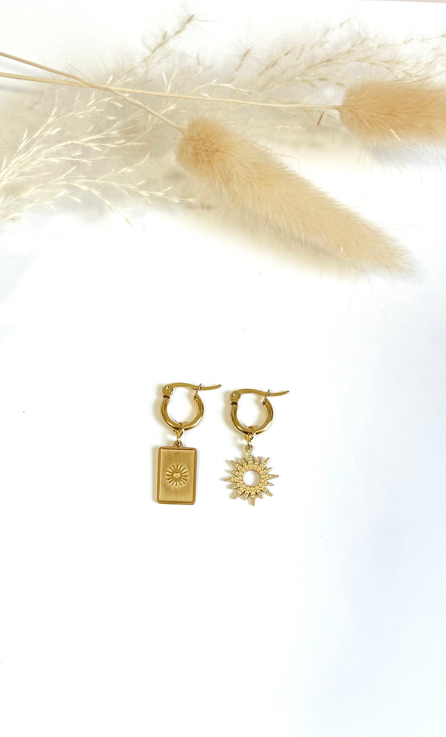 Boucles d’oreille dépareillées en acier inoxydable argenté avec soleil. Mix and match.