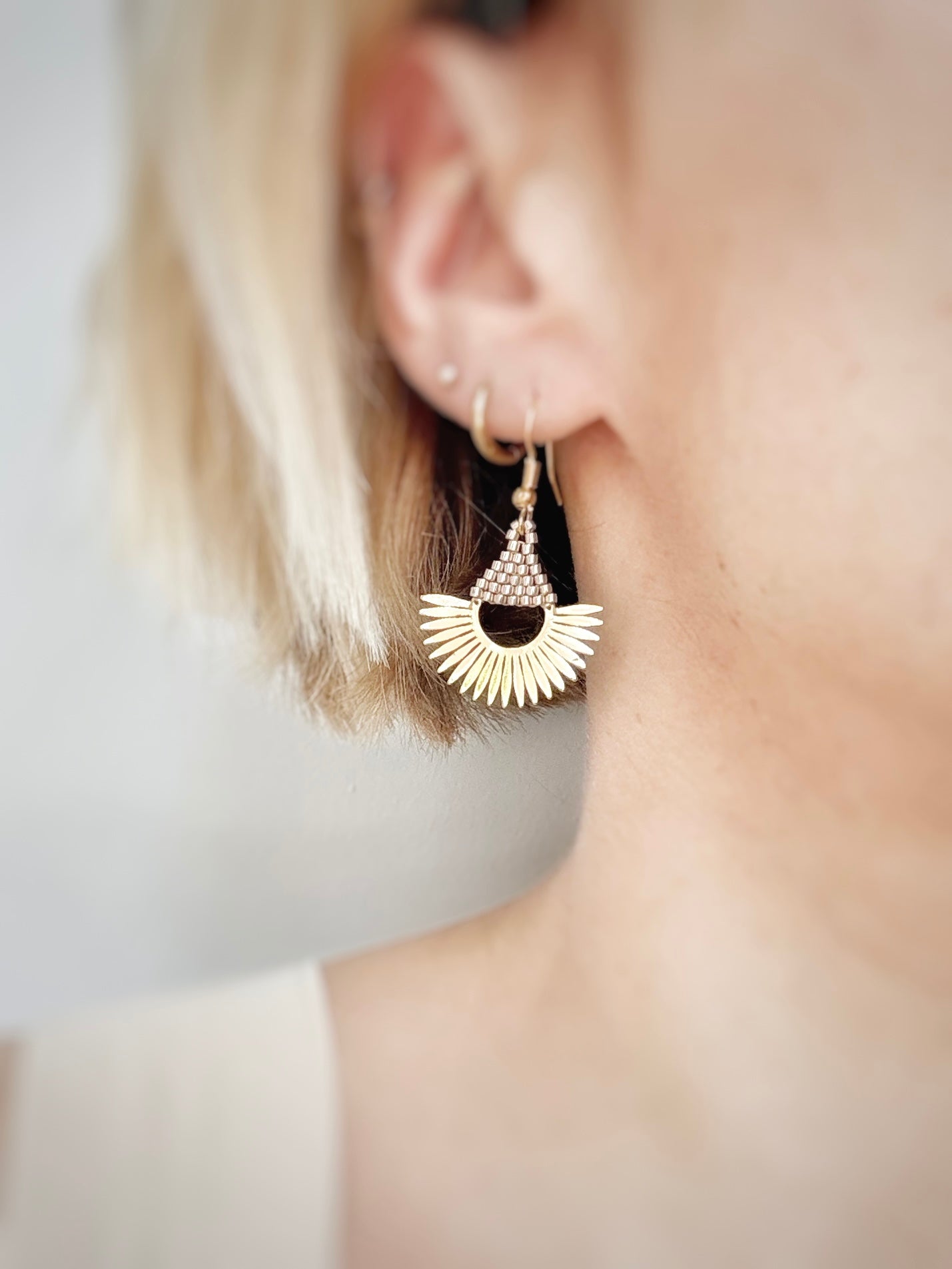 Boucles d’oreilles demi-soleil en laiton plaqué or 18 carats et perles de verre champagne.
